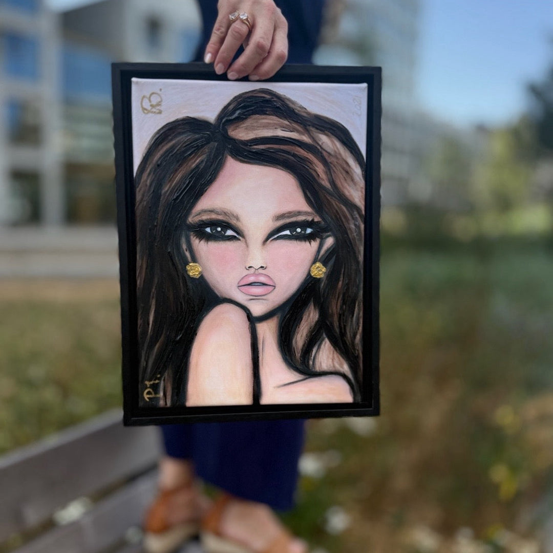 A framed portrait painting of a woman with dark hair and gold earrings, held up by a person standing on a bench outdoors with a blurred park background.